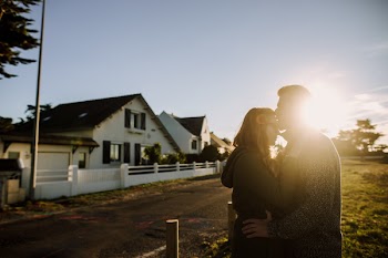 Man Kissing Woman's Forehead Under Sunset