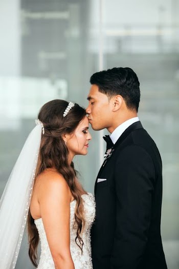man kissing woman on forehead