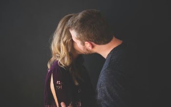 man kissing woman's cheek