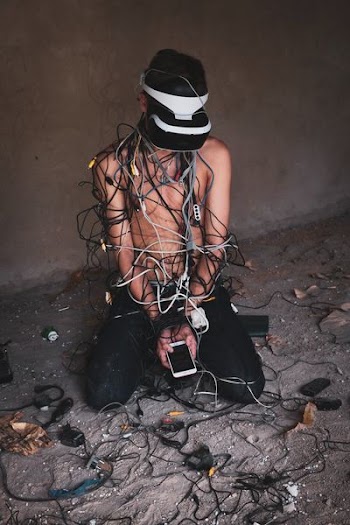 man kneeling beside electronic devices