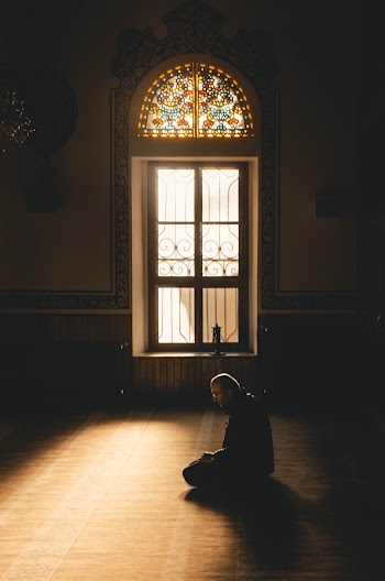 Man Kneeling While Praying