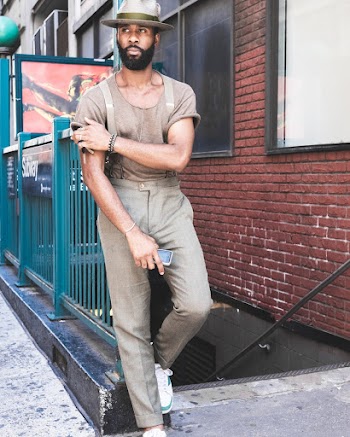 Man Leaning Back on Railing Near Wall and Stairs