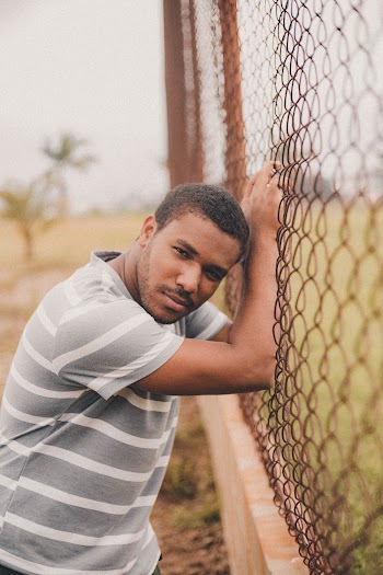 Man Leaning Beside Fence