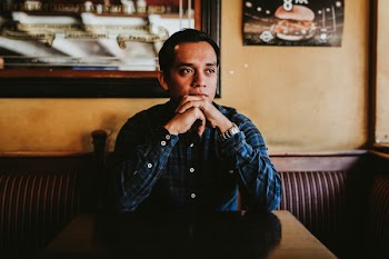 Man Leaning His Chin on His Two Hands