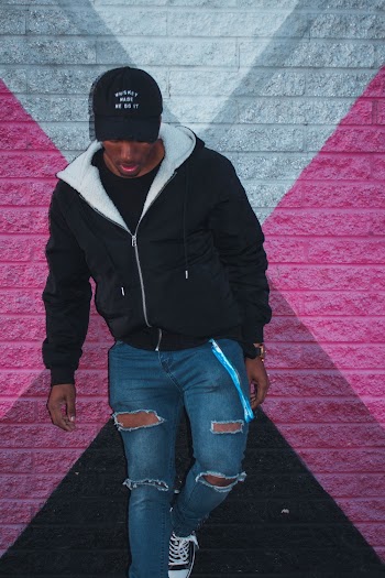Man Leaning in Front of Pink and White Wall