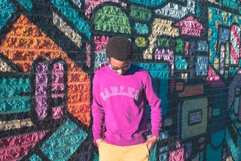 Man Leaning Multicolored Wall