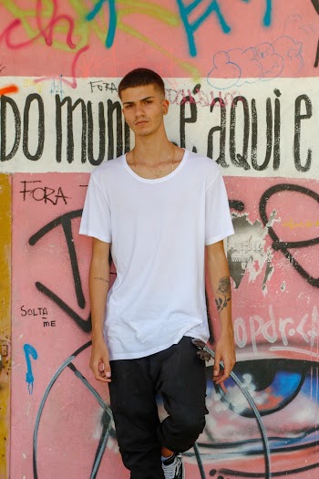Man Leaning On A Graffiti Filled Wall