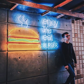 Man Leaning On A Wall With Signage