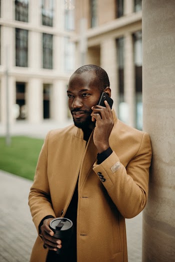 Man Leaning on Beige Post