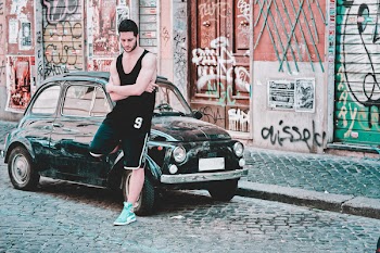 Man Leaning On Black 3-door Hatchback