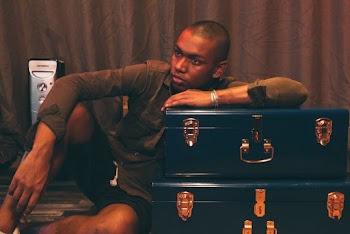 Man Leaning on Blue Suitcase