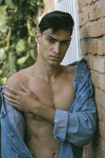 Man Leaning on Brick Wall Outside