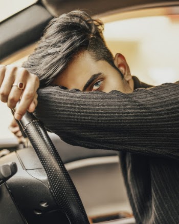 Man Leaning on Car Steering Wheel