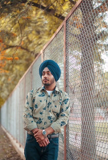 Man Leaning On Chain Link Fence