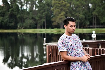 Man Leaning on Fence Near River