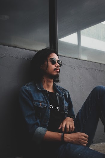 Man Leaning On Gray Concrete Wall