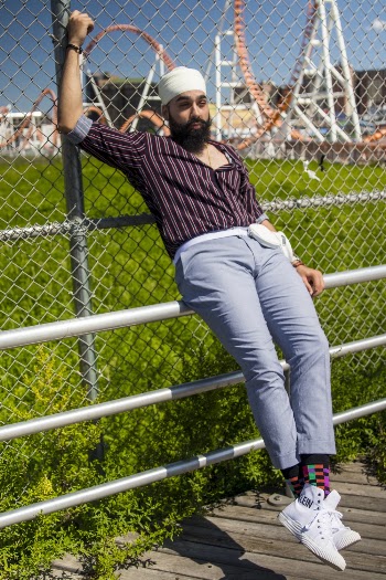 Man Leaning on Link Fence While Sitting On A Railing