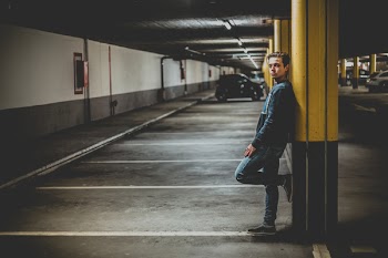 Man Leaning on Post