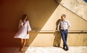 Man Leaning on Rail Facing a Woman in White Dress