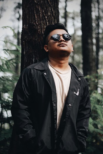 Man Leaning on Tree
