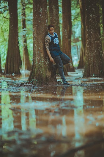 Man Leaning on Tree