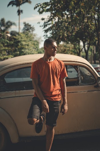 Man Leaning on Volkswagen Beetle Car