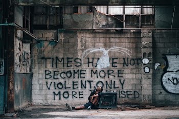 man leaning on wall with text