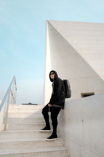 man leaning on white deck while standing in stairway