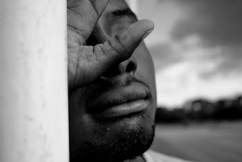 Man Leaning on White Wall