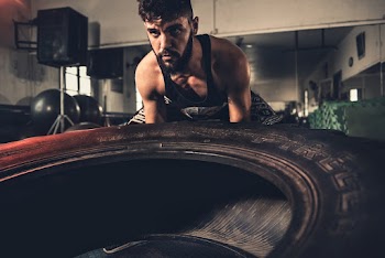 Man Lifting Vehicle Tire