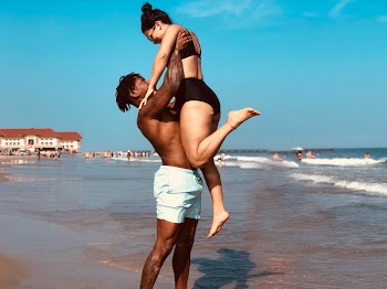 Man Lifting Woman on Seashore