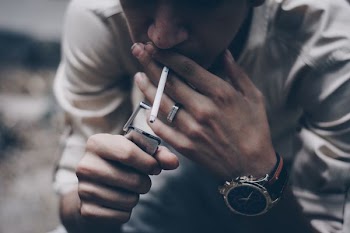 man lighting cigarette stick