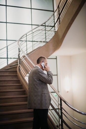 Man Listening to Smartphone While Standing on Staircase