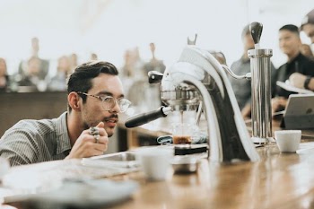 man looking at coffee in coffeemaker