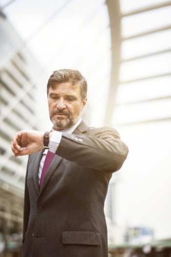Man Looking at His Watch Inside Complex Building