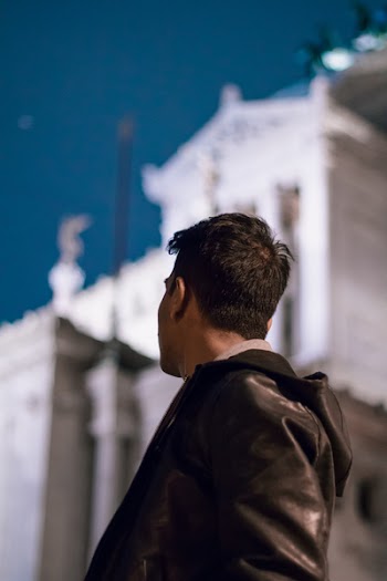 Man Looking at White Concrete Building