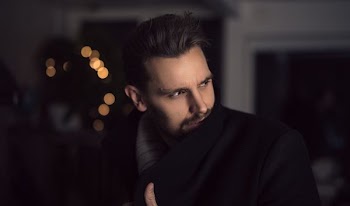 man looking left while holding his jacket