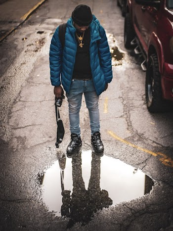 Man Looking on Puddle on Road