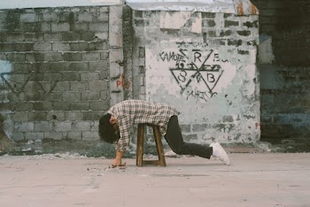 Man Lying Forward on Stool Near Wall