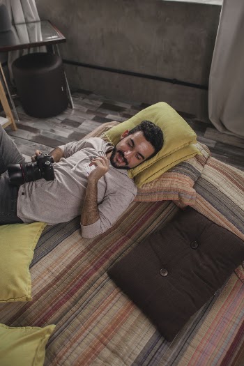 Man Lying On Bed Holding Camera