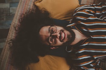 Man Lying on Bed Smiling