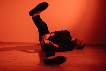 Man Lying on Floor While Raising Right Foot