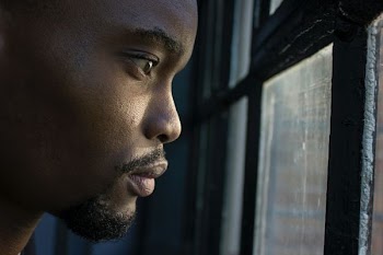 man near glass window pane