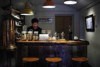 Man on Black Polo Shirt Is Standing Infront of Bar Counter