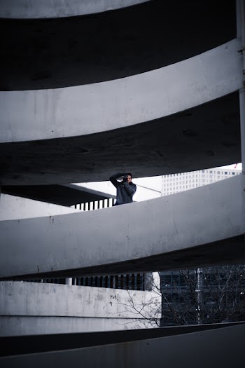 Man on Concrete Building Taking Photo