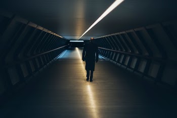 Man on Escalator in Illuminated Room