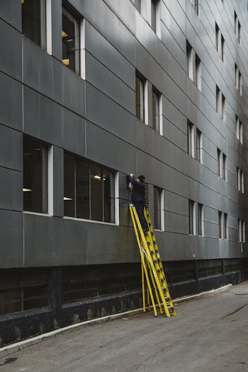 Man On Ladder Changing Outdoor Light