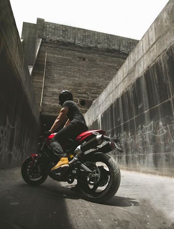 man on motorcycle between concrete walls near concrete building