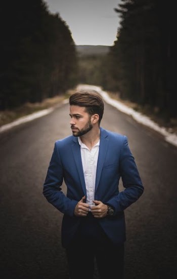 man on road wearing blue suit jacket
