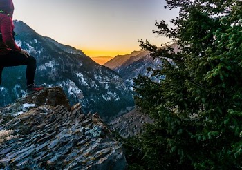 man on rock in front of mountain view